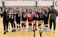 a group of volleyball players posing for a picture