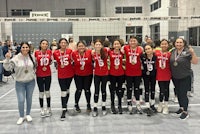 a group of volleyball players posing for a picture