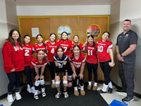 a group of volleyball players posing for a picture