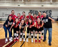 a group of volleyball players posing for a picture