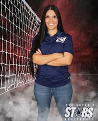 a woman standing in front of a volleyball net