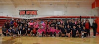 a group of people posing for a picture in a gym